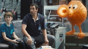 (Matthew Lintz) and Sam Brenner (Adam Sandler) with Q*bert in Columbia Pictures' PIXELS.